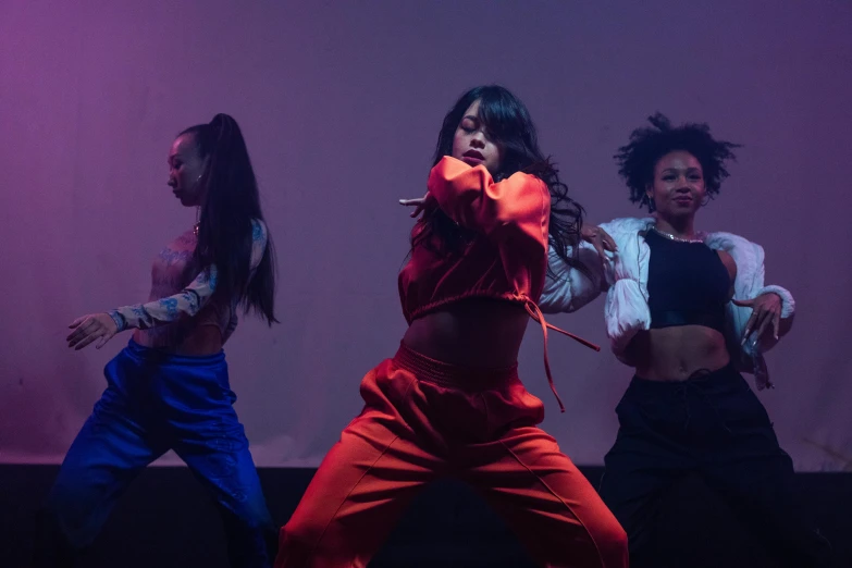 three women on stage in red pants and white shirts