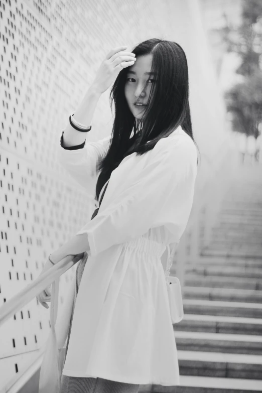 a woman that is standing on some stairs, a black and white photo, inspired by Ma Yuanyu, tumblr, wearing white cloths, bae suzy, white background!!!!!!!!!!, female with long black hair