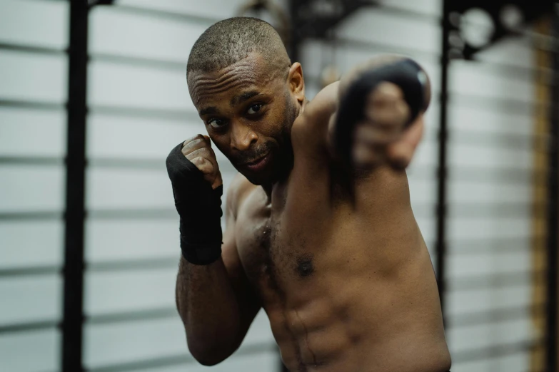 a close up of a person wearing boxing gloves, by Sam Charles, pexels contest winner, figuration libre, fighter pose, background image, man is with black skin, working out