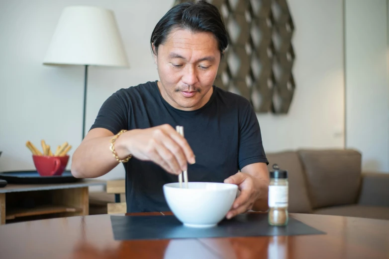 a man sitting at a table with a bowl of food, inspired by Yasushi Sugiyama, blending, carefully crafted, profile image