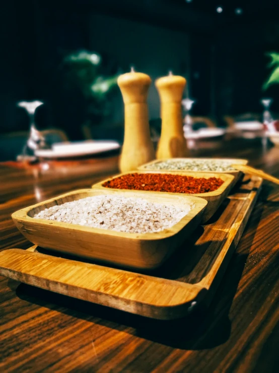 a tray of food sitting on top of a wooden table, salt, volcanic embers, very elegant & complex, high quality product image”