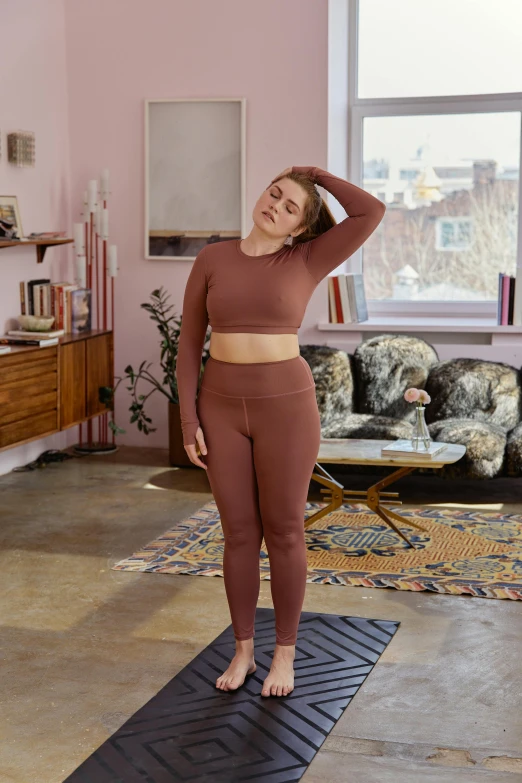 a woman is standing on a yoga mat in a room with pink walls