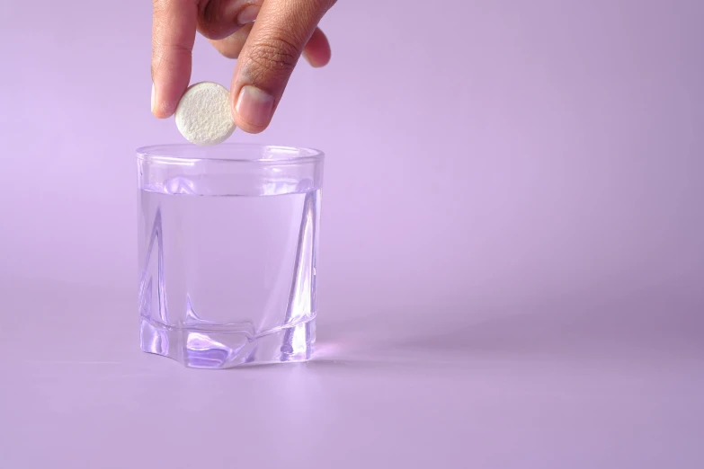 someone throwing a coin into a glass to drink