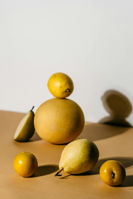 a group of pears sitting on top of a table, a still life, by Doug Ohlson, trending on pexels, golden orbs, made of food, suns, minimalist photo