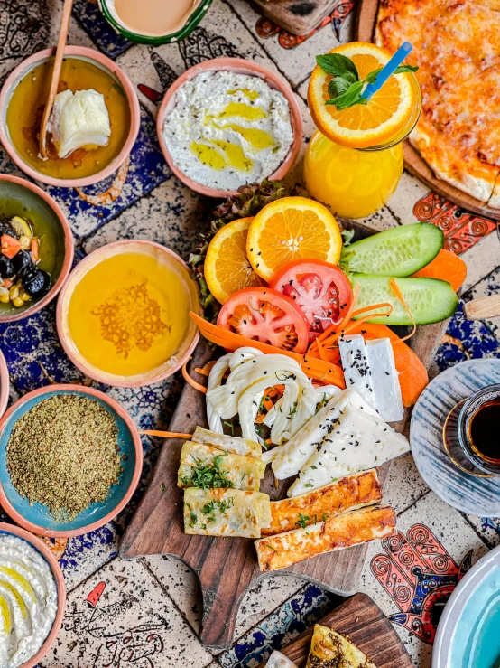 a table topped with lots of different types of food, dau-al-set, orange and blue tones, thumbnail, breakfast, eytan zana