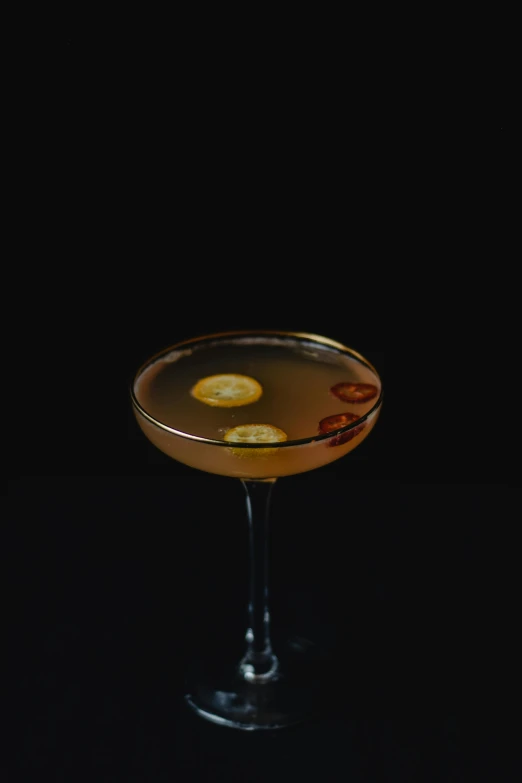 a glass filled with a drink sitting on top of a table, inspired by Carlo Martini, renaissance, on a black background, yellow aureole, flying saucer, 3 / 4 wide shot