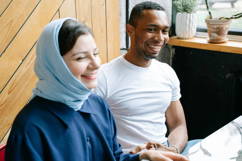 a man and a woman sitting at a table, pexels contest winner, hurufiyya, wearing a scarf, happy smiling, 15081959 21121991 01012000 4k, muslim