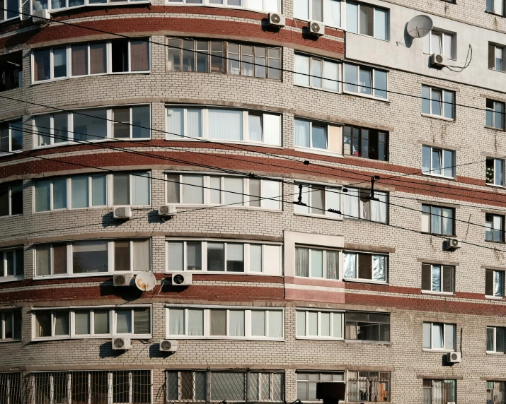 a tall brick building with lots of windows, inspired by Elsa Bleda, unsplash, brutalism, rostov city, 2000s photo, stacked houses, ten flats