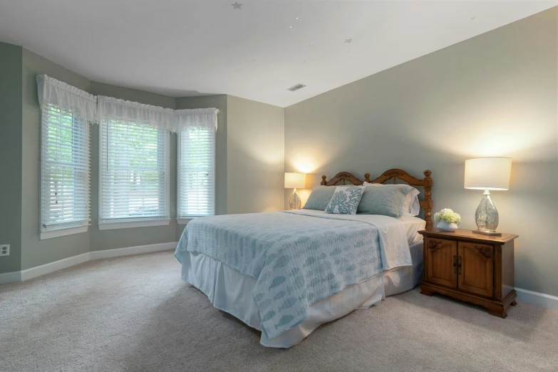 this bedroom has a bed and two lamps with shades on them