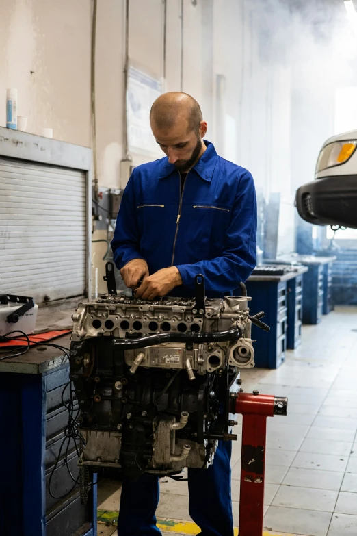 a man working on a car engine in a garage, white wall coloured workshop, large blue engines, 2995599206, aftermarket parts