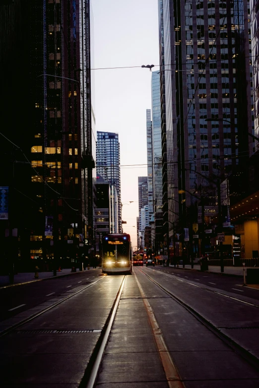 a train traveling down a city street next to tall buildings, pexels contest winner, calm evening, toronto, portra 8 0 0 ”, street tram