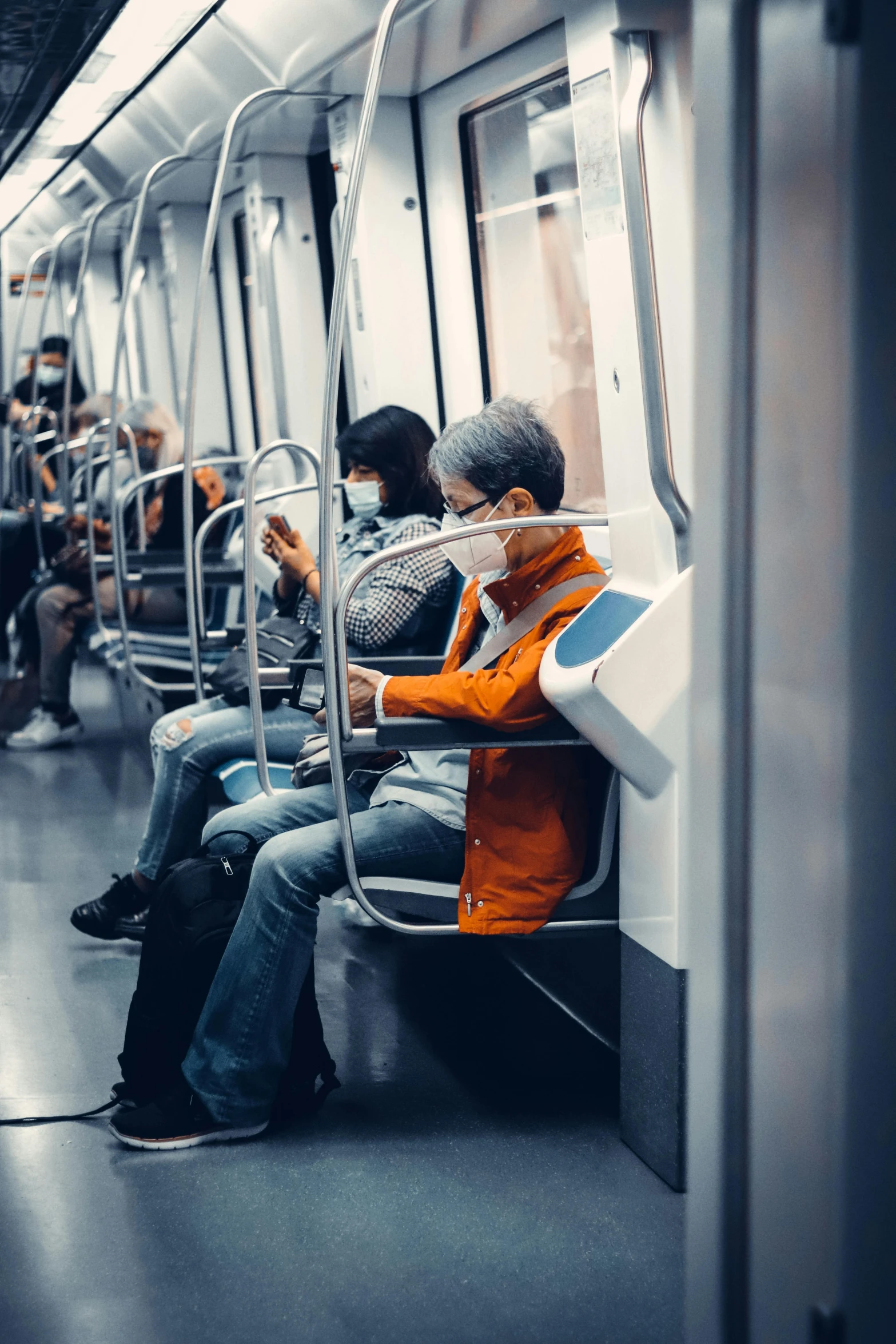 people wearing masks sit on public transportation