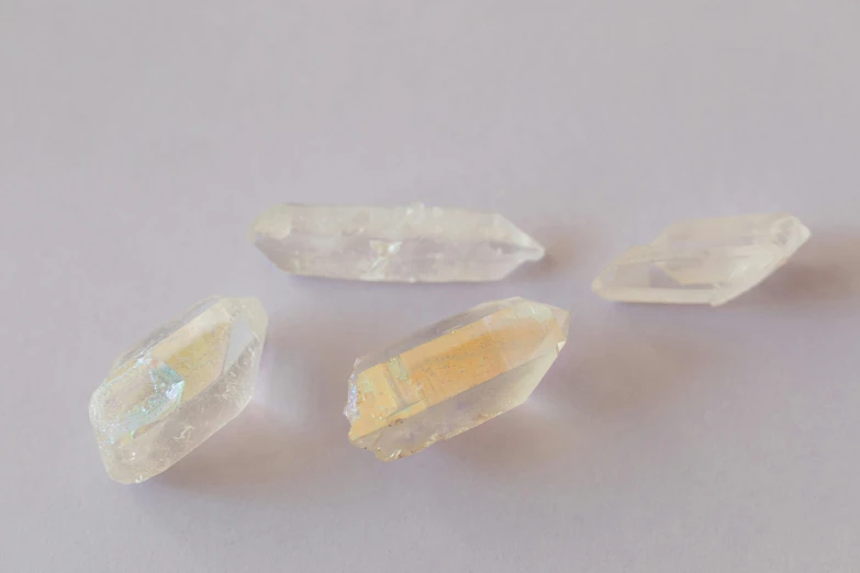 a group of crystals sitting on top of a table, a hologram, by Rachel Reckitt, unsplash, gradient white to gold, ancient fairy dust, on a pale background, close-up product photo