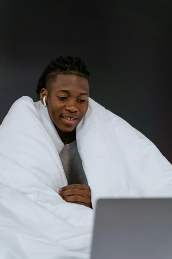 a man wrapped up in a blanket using a laptop, an album cover, inspired by Xanthus Russell Smith, trending on pexels, happening, playboi carti, all overly excited, white sheets, programmer