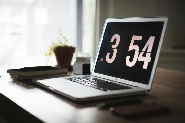 a laptop computer sitting on top of a wooden desk, by Romain brook, unsplash, computer art, countdown, clocks, 3 4 5 3 1, three - quarter view