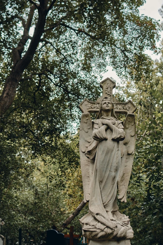 a statue of an angel in a cemetery, pexels contest winner, art nouveau, built into trees and stone, holy cross, parce sepulto, a tall