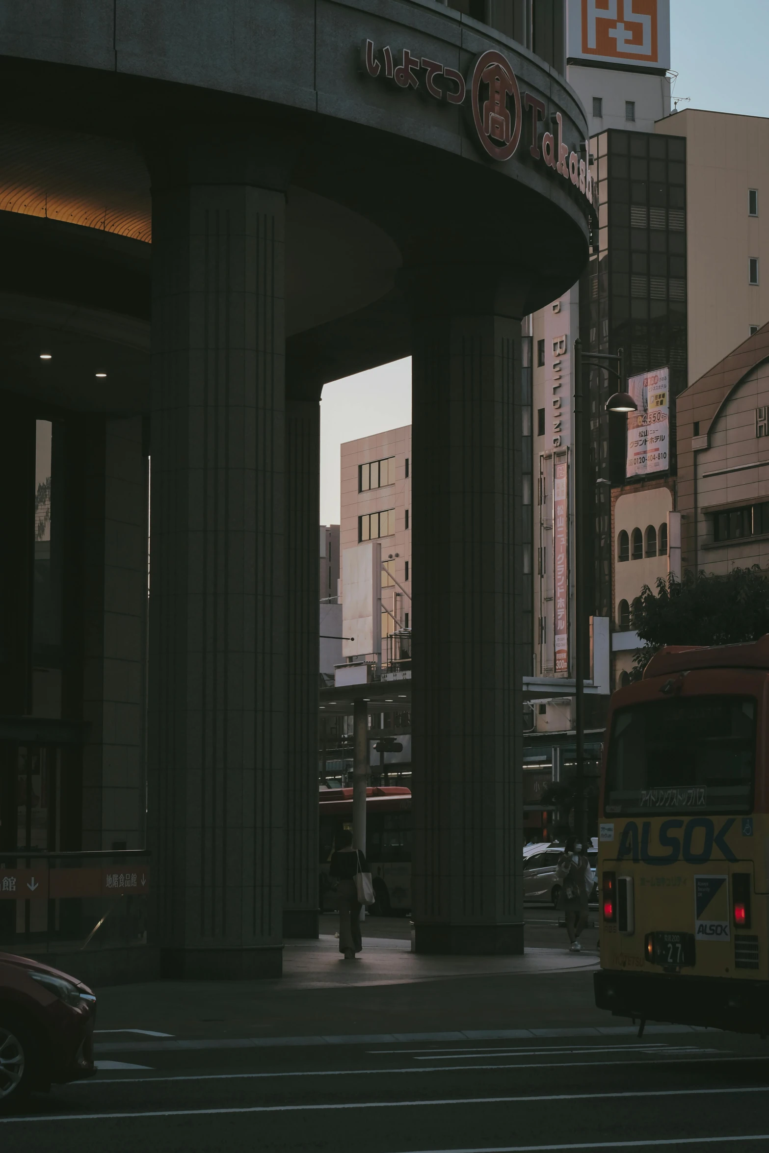 city skyline with bus and cars passing in front