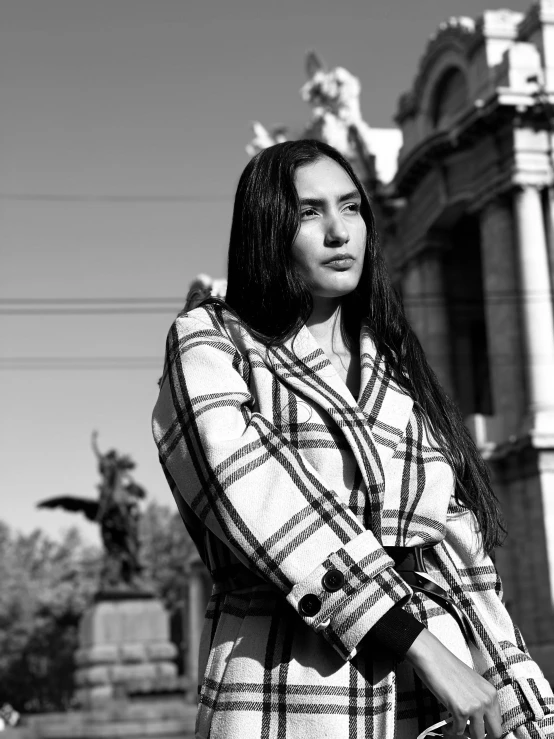 a black and white photo of a woman in a plaid coat, by Glòria Muñoz, on a bright day, young handsome pale roma, andrey surnov, majestic saint woman