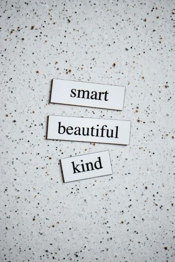a piece of paper with the words smart beautiful kind on it, a picture, trending on pexels, white ceramic shapes, enamel, concrete poetry, labels