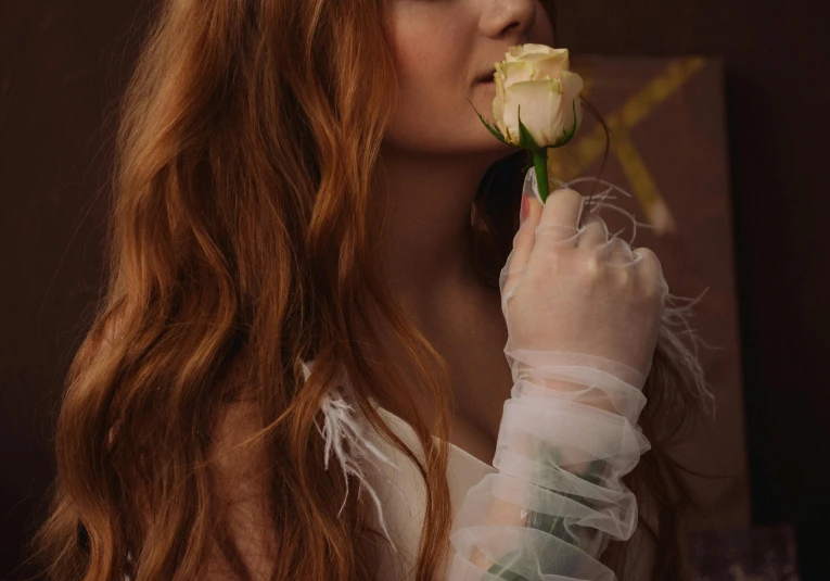 a beautiful woman holding a rose in her hand