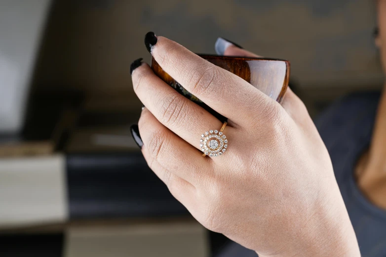 a close up of a person holding a cell phone, inspired by L. A. Ring, trending on pexels, arabesque, gold gilded circle halo, ornate with white diamonds, petite, handcrafted