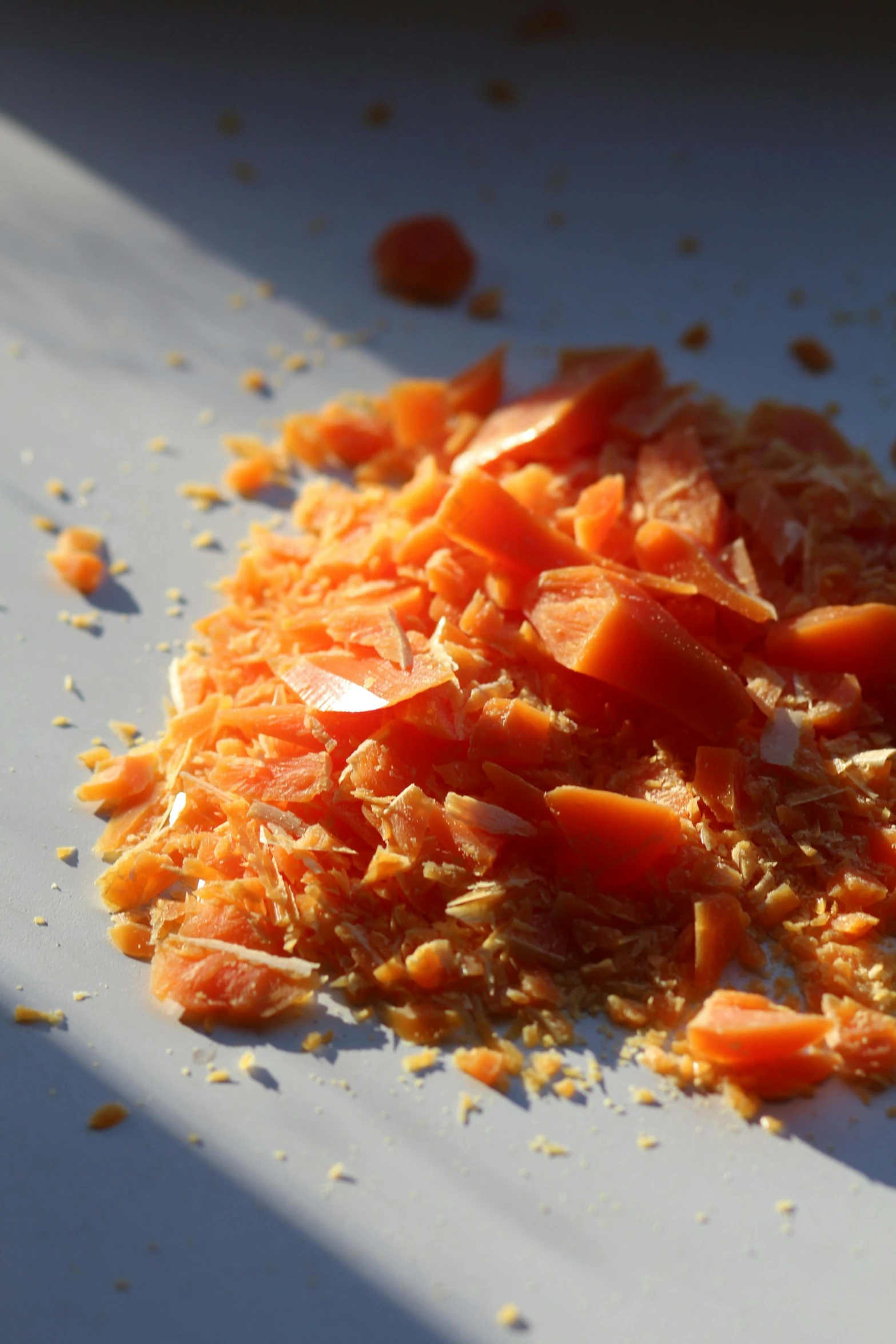 a pile of carrots sitting on top of a white plate, a microscopic photo, by Jessie Algie, red meat shreds, in the sun, strong eggshell texture, photographed for reuters