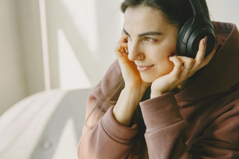 a close up of a person wearing headphones, by Emma Andijewska, trending on pexels, sitting on a window sill, serene smile, girl with brown hair, thumbnail