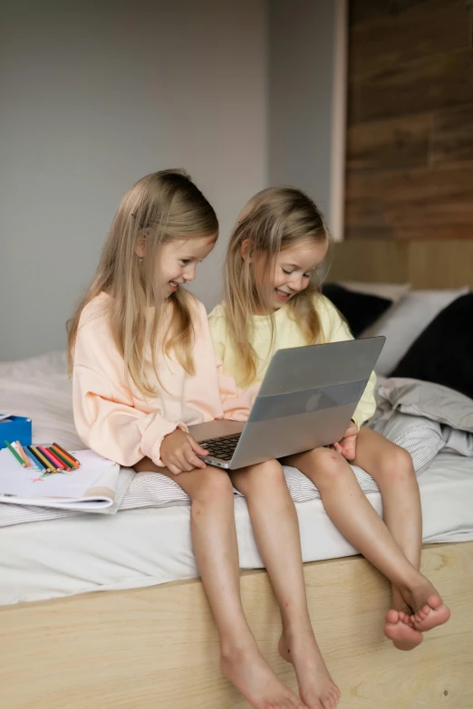 two little girls sitting on a bed with a laptop, by Jan Gregoor, pexels, programming, tech robes, gif, childs bedroom