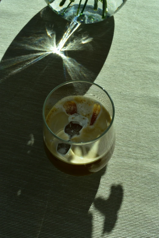 a bowl of fruit and cream on a table with a shadow cast on it