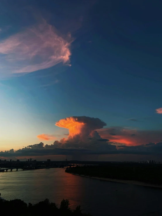 a big long cloud in the sky over some water