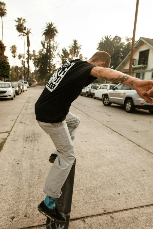 a man riding a skateboard down the side of a street, wearing pants and a t-shirt, epic stance, stretch, lynn skordal