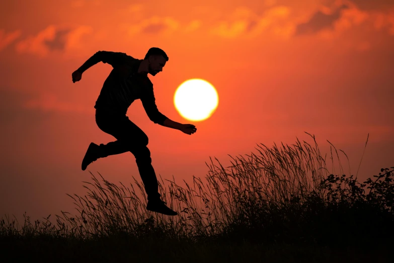 a man running across a field at sunset, pexels contest winner, jump, balance, profile pic, ((sunset))