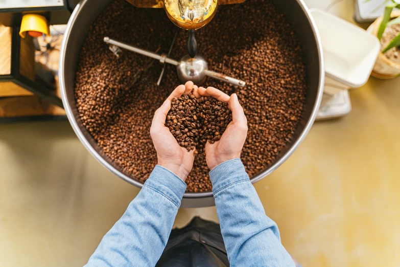 a person using a coffee grinder to grind coffee beans, by Julia Pishtar, trending on unsplash, bird's view, avatar image