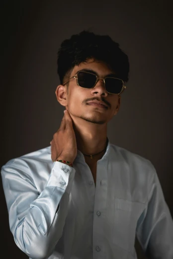 a young man with sunglasses posing for the camera