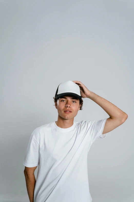 a man in a white shirt and black hat is posing for the camera