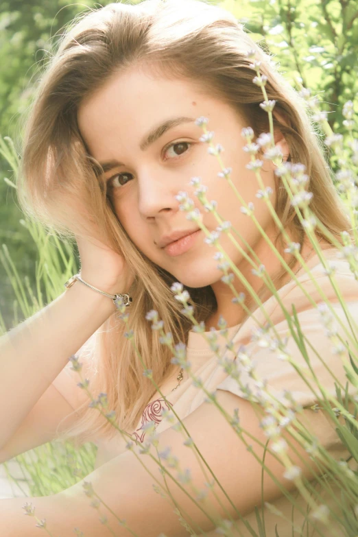 a beautiful young woman sitting on top of a lush green field, a colorized photo, inspired by Elsa Bleda, trending on pexels, 🤤 girl portrait, flowers on heir cheeks, florence pugh, soft blur lighting