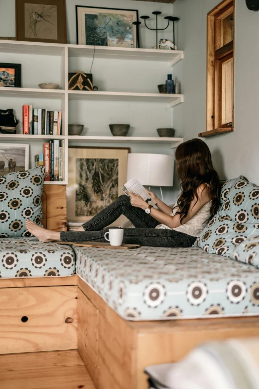 a woman that is sitting on a bed with some pillows