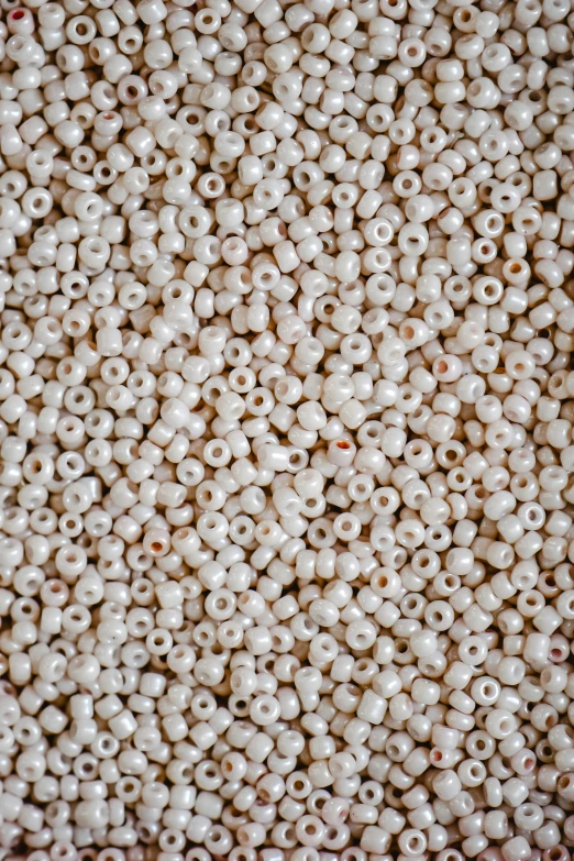 a pile of white beads sitting on top of a table, inspired by Perle Fine, renaissance, heavy grain-s 150, cherry, ground - level medium shot, mexico