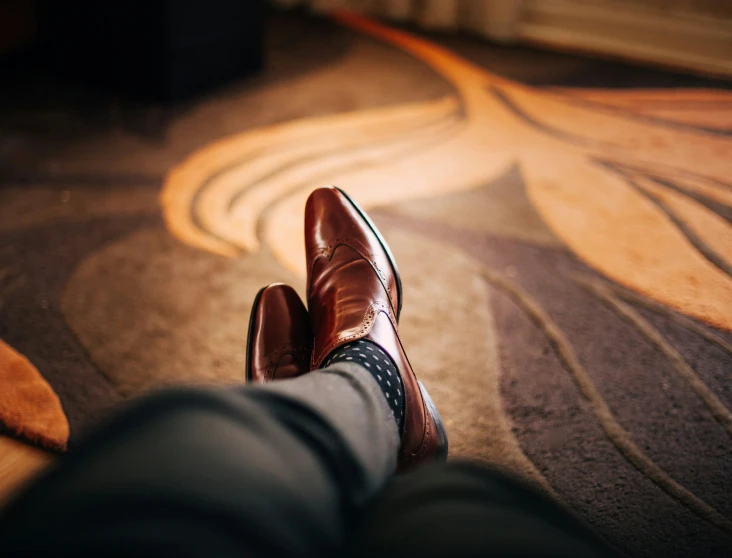 a person in brown shoes, a dress suit and tie and a striped tie