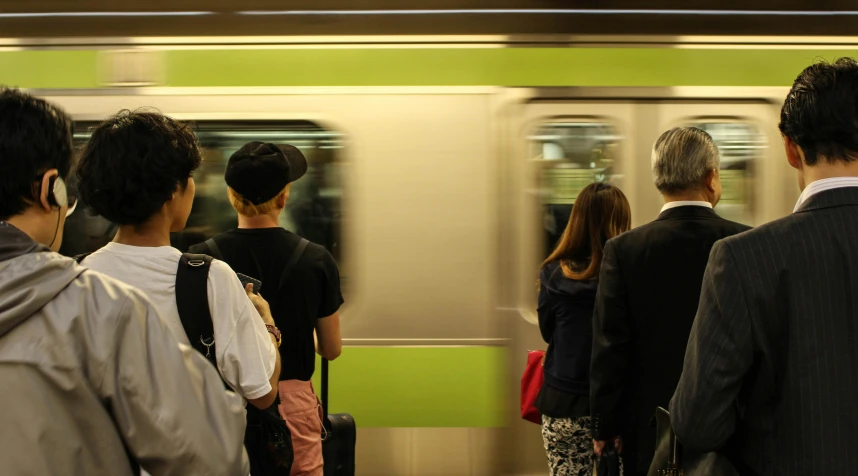 a group of people waiting to board a train, unsplash, arasaka, black and green scheme, getty images, thumbnail