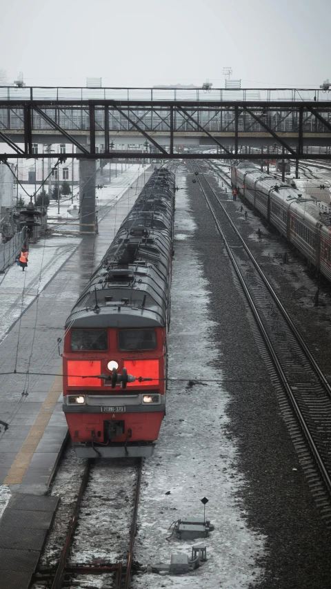 a large long train on a steel track, by Ihor Podolchak, vibrant but dreary red, moscow, train station, stockphoto
