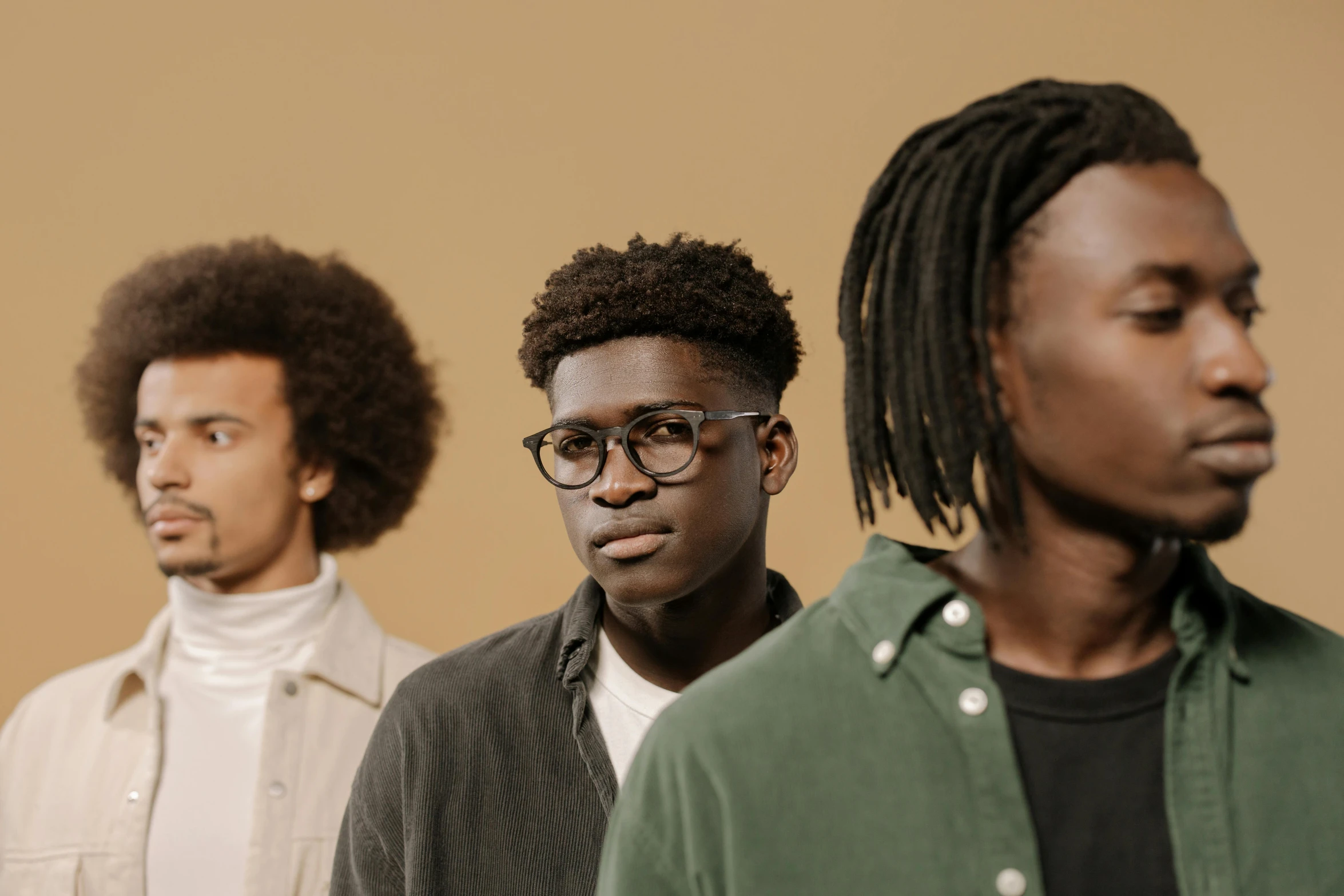 a group of young men standing next to each other, trending on pexels, black arts movement, long afro hair, some glints and specs, fine lines, brown clothes