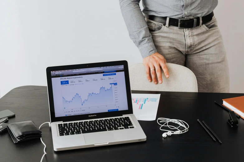 a woman standing in front of a laptop computer, a photo, trending on pexels, analytical art, man standing, displaying stock charts, ad image, with a laptop on his lap