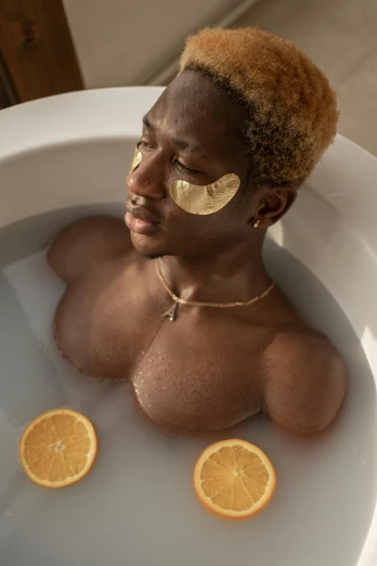 a close up of a person in a bath tub with orange slices, afrofuturism, lean man with light tan skin, non binary model, face mask, luxurious onsens