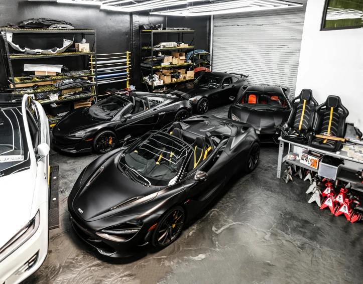 a garage filled with lots of black sports cars, featured on reddit, tech robes, lotus, studio shot, lacquered