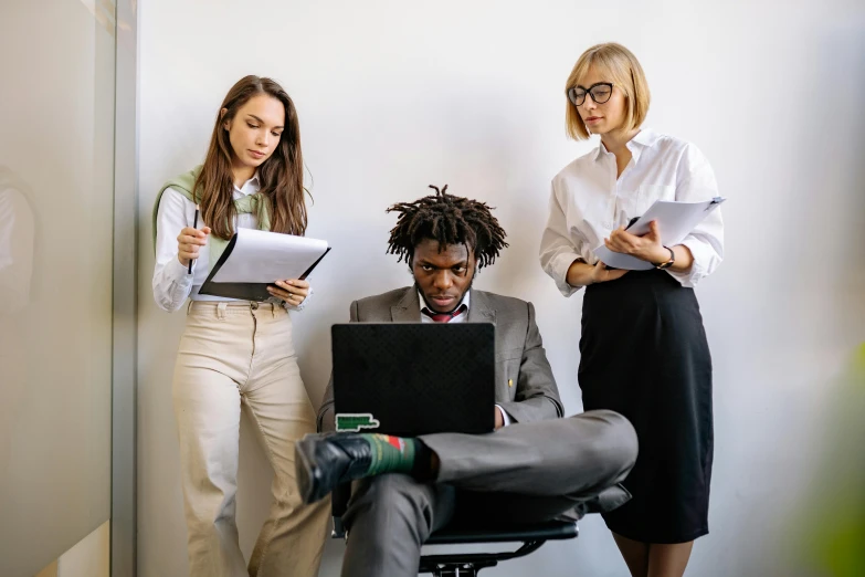 a couple of women standing next to a man on a laptop, trending on pexels, siting in a chair, avatar image, professional image, black people