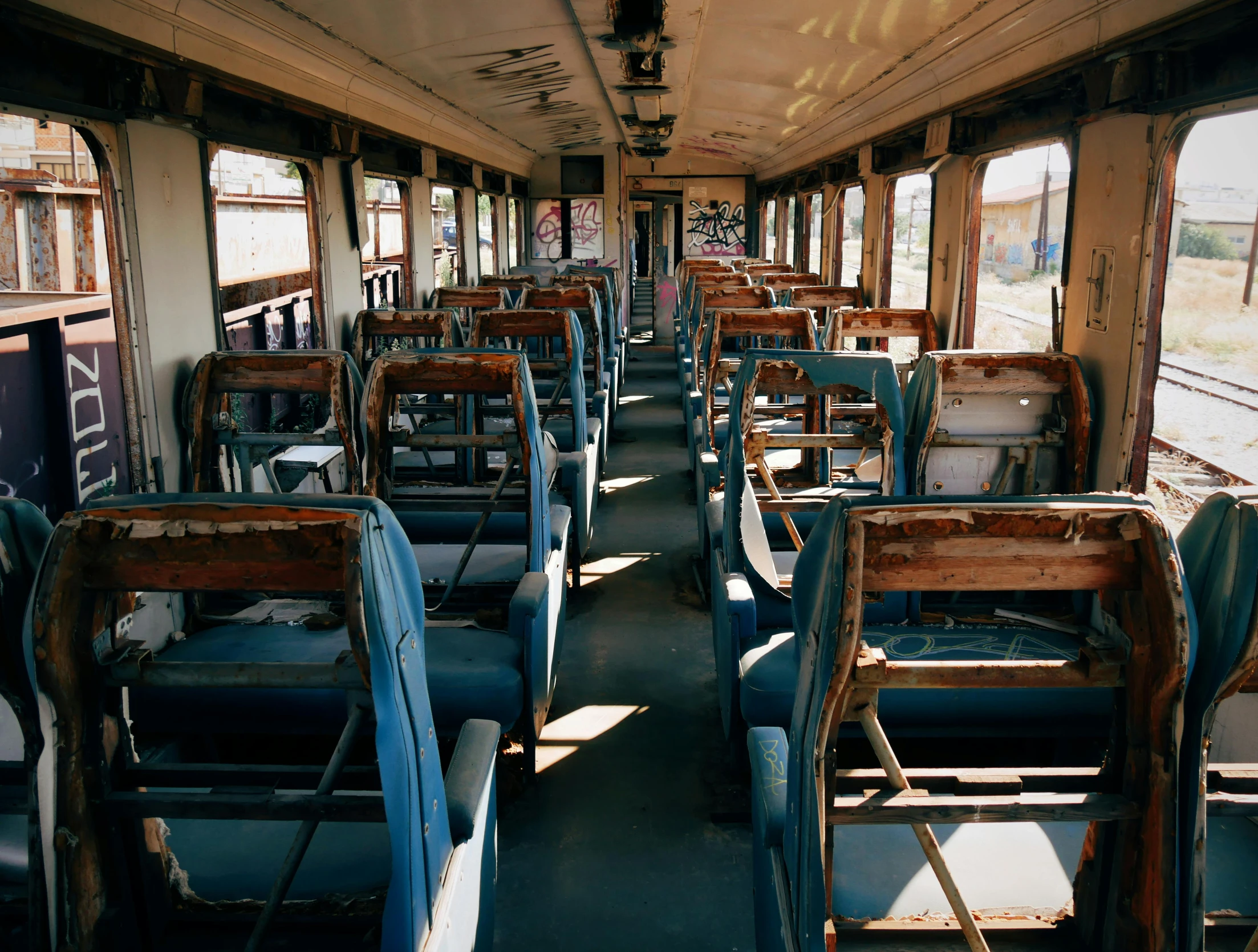an empty passenger train car with rows of chairs on each side