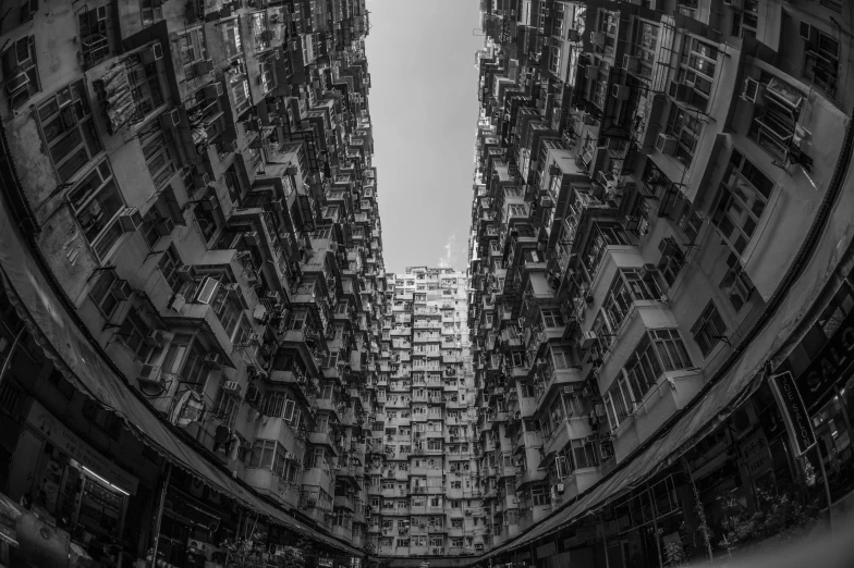 a black and white photo of a very tall building, by Patrick Ching, pexels contest winner, kowloon walled city style, wide angle shot 4 k hdr, bladerunner apartment, perfect symmetrical image