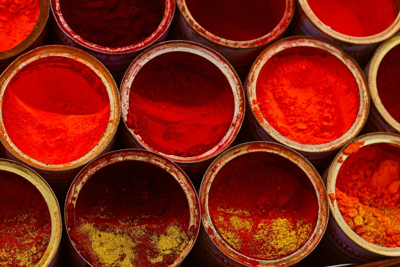 a group of buckets filled with red and yellow paint, inspired by Steve McCurry, trending on unsplash, textiles, paprika, intense sunlight, india ink