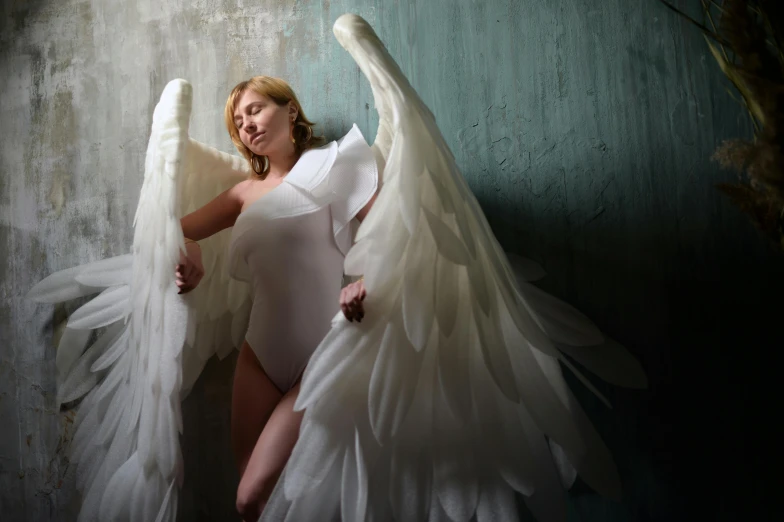 a woman in a white dress posing for a picture, an album cover, inspired by Marie Angel, big angel wings wide open, 5 0 0 px models, 2010s, costume design made with love